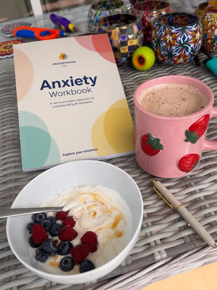 Anxiety Workbook next to breakfast and a hot drink